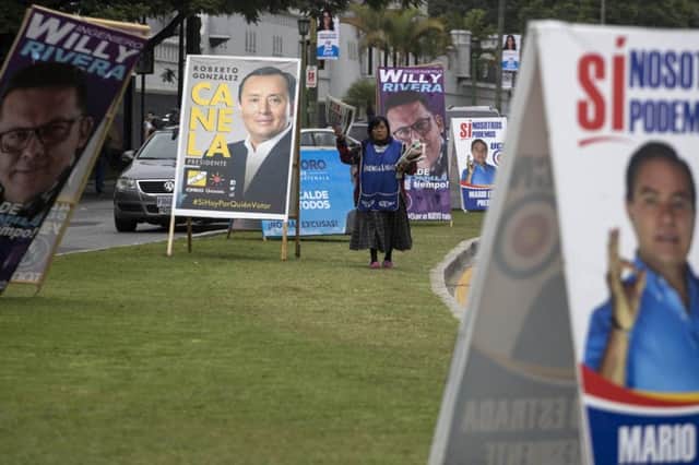 A newspaper vendor walks through a row of signs promoting candidates in Guatemala City. Picture: AP