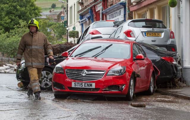 Rescue teams wade through floodwater on the streets of Alyth, in Perthshire. Picture: Hemedia