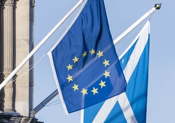An EU flag flies with a Saltire above Edinburgh. Picture: Ian Georgeson