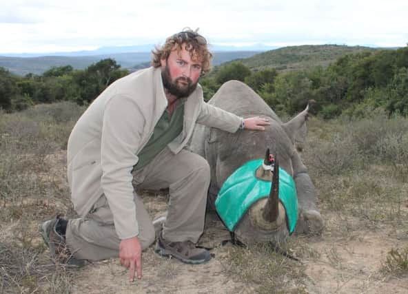 Dr Paul ODonoghue with a sedated rhino ready to have a satellite camera fitted in a bid to halt poaching. Picture: PA