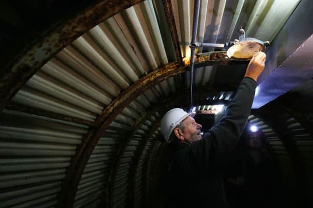 A 

National Trust volunteer explores the tunnels. Picture: PA