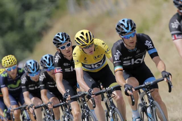 Chris Froome, in the leaders yellow jersey, rides with team-mates Nicolas Roche, right, and Geraint Thomas. Picture: AP