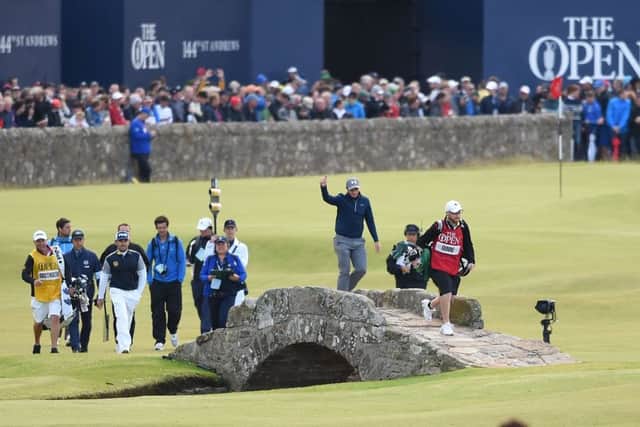 Paul Dunne, a 22-year-old amateur from Dublin, takes some well-earned applause as he heads over the Swilcan Bridge. Picture: Ian Rutherford