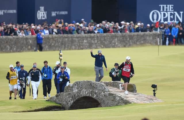 Paul Dunne, a 22-year-old amateur from Dublin, takes some well-earned applause as he heads over the Swilcan Bridge. Picture: Ian Rutherford