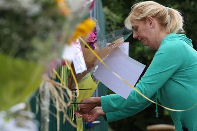 A member of the public ties flowers to the gate outside Jessicas school in Hull. Picture: rossparry.co.uk