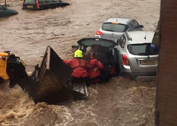 Firemen and members of the public rescued pensioner Jinty Young from her car during severe flooding in Alyth. Picture: Cascade News