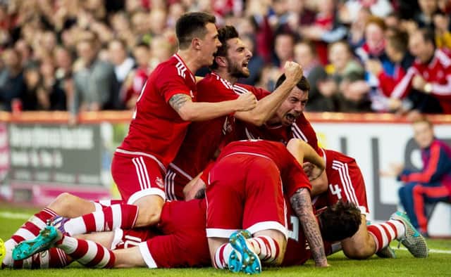 Team-mates mob Niall McGinn after scoring for Aberdeen. Picture: PA