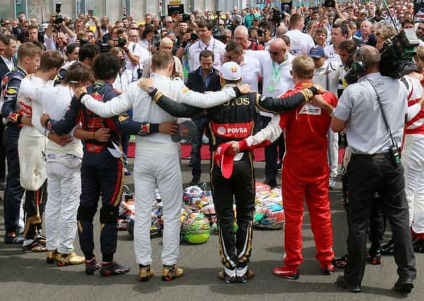 Formula 1 drivers embrace for a minutes silence to remember Jules Bianchi before the Hungarian Grand Prix.  Picture: AP