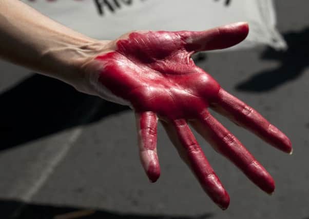 A woman with her hand painted red to signify blood. Picture: AP