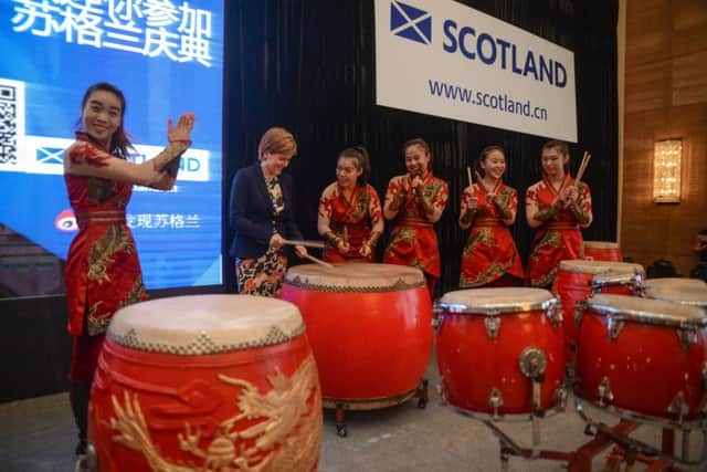 Sturgeon tries her hand at the drums with the Beijing Red Poppy Ladies Percussion Group during her visit to China yesterday. Picture: Contributed
