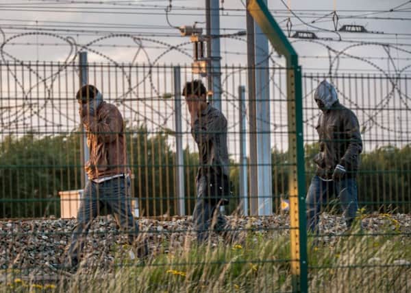 Migrants who successfully crossed the Eurotunnel terminal walk on the side of the railway as they try to reach a shuttle to the UK. Picture: AFP/Getty Images