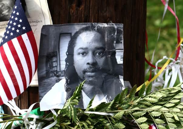 Photos of Samuel DuBose hang on a pole at a memorial in Cincinnati. Picture: AP