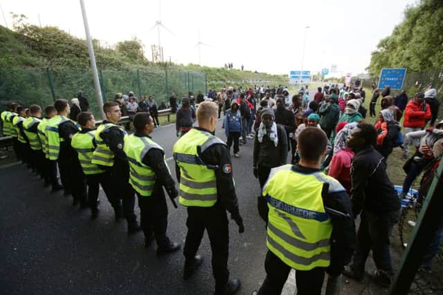 Migrants face a police cordon by the Eurotunnel perimeter fence. Picture: PA