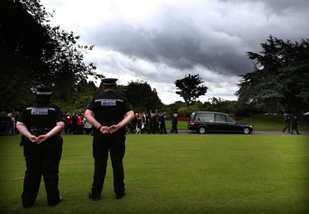 Police officers look on as mourners follow the coffin of Lamara Bell. Picture: PA