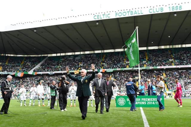 Celtic legend John Clark waves to the fans after unfurling the league flag. Picture: SNS