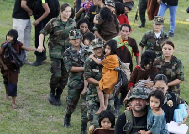 Peruvian soldiers usher adults and children from helicopters at the air force base in Mazamari after their liberation from guerrilla group Shining Path. Picture: FP/Getty Images