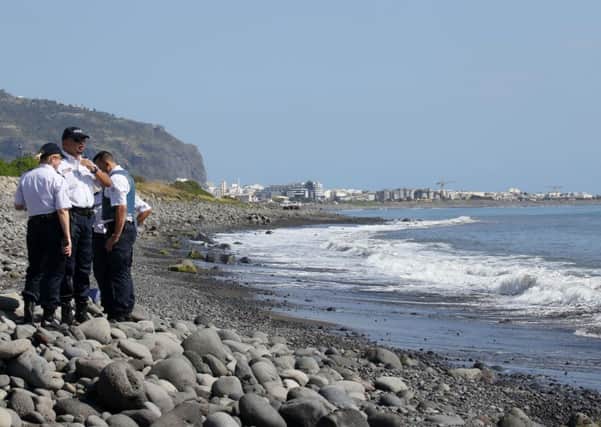 Police officers inspect metallic debris found on a beach in Saint-Denis on the French Reunion Island in the Indian Ocean, close to where where a Boeing 777 wing part believed to belong to missing flight MH370 washed up last week. Picture: AFP/Getty Images