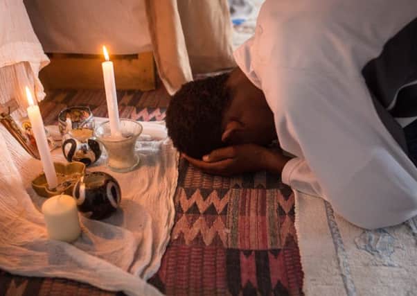 A man prays during an Orthodox service for Ethiopian and Eritrean worshippers at a church in a makeshift camp near the port of Calais. Picture: Getty Images