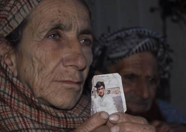 Shafqat Hussains mother Makhni Begum holds up his photograph. Picture: AP