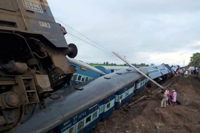 Indian officials stand next to two passenger trains on top of each other following the derailment: AFP/Getty