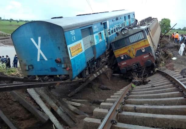 Two Indian passenger trains lay next to each other following a derailment after they were hit by flash floods on a bridge. Picture: AFP/Getty