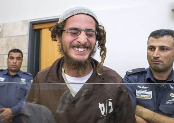 Meir Ettinger, the head of a Jewish extremist group, laughs outside court in Nazareth Illit after his arrest. Picture: Getty Images