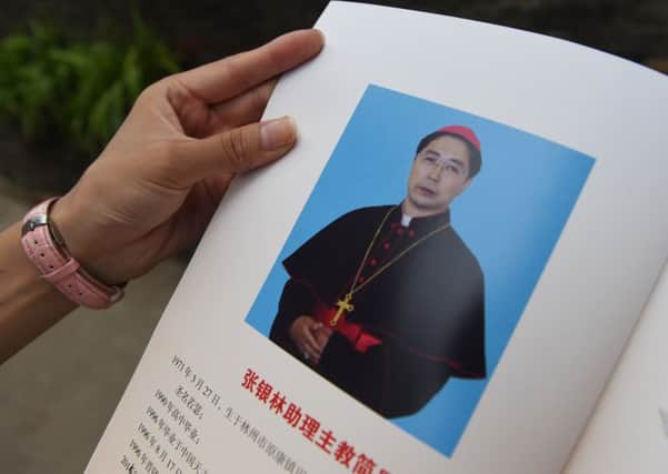 A worshipper holds a picture of Joseph Zhang Yinlin. Picture: AFP/Getty Images