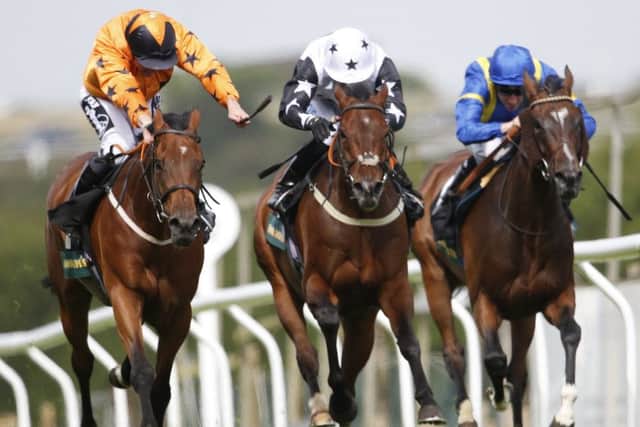Jim Crowley riding Pyrocumulus (orange) win The John Smith's Brighton Mile Challenge trophy at Brighton racecourse. Picture: Getty Images