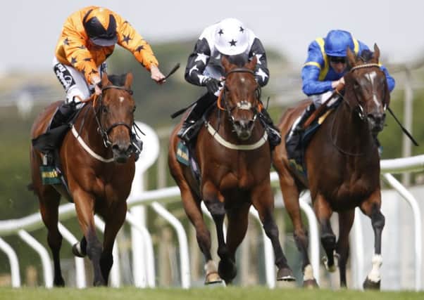 Jim Crowley riding Pyrocumulus (orange) win The John Smith's Brighton Mile Challenge trophy at Brighton racecourse. Picture: Getty Images