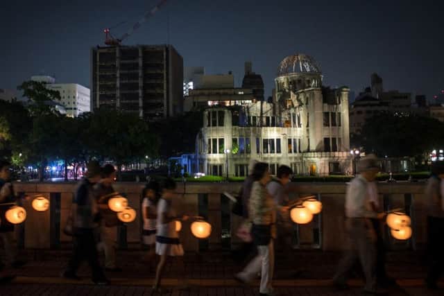 People carry lanterns past the Atomic Bomb Dome at the Hiroshima Peace Memorial Park. Picture: Getty
