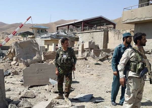 Afghan security forces inspect the damage caused after a suicide bomber blew up a truck in eastern Logar province killing eight people.  Picture: AFP/Getty Images