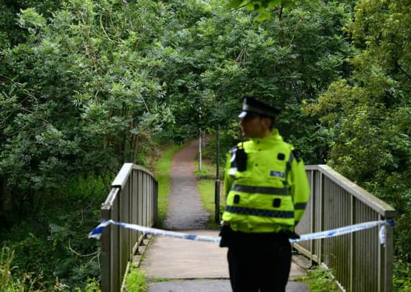 A police officer on the scene where human remains were found in Riverside Park, Glenrothes, left, and a poster from the search for Kenneth Jones. Picture: Hemedia
