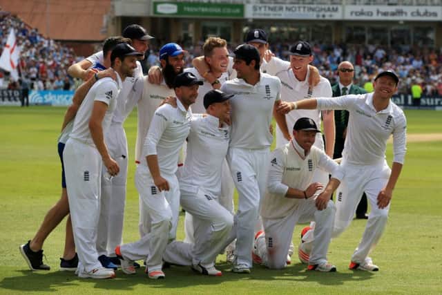 England captain Alastair Cook looks back at his celebrating teammates. Picture: PA