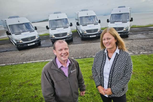 Stuart McCaw, operations director at Highland Experience with Julie Brown, bank relationship manager, and four of the new buses