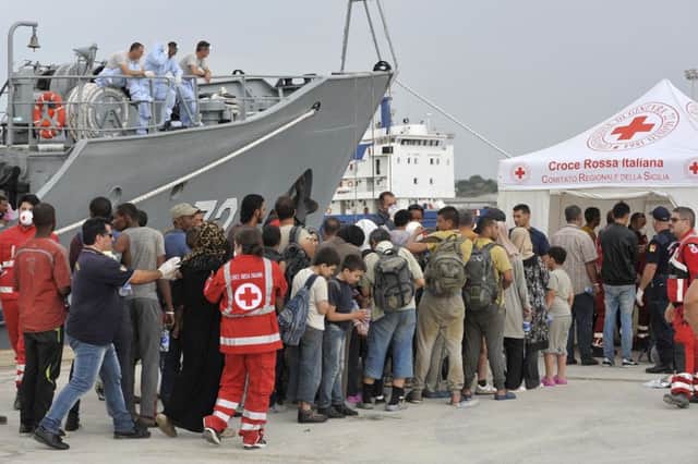 Migrants line up after disembarking from a Croatian coast guard ship in Sicily after at least 40 migrants died in the hold of an overcrowded smuggling boat. Picture: AP