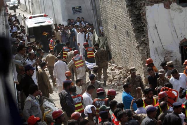 Pakistani rescue workers recover bodies from the rubble at the site of the suicide bombing in Attock. Picture: AP