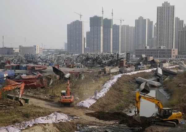 The crumpled remains of the factory against the backdrop of some of the Tianjin flats that were damaged in the series of explosions. Picture: AFP/Getty