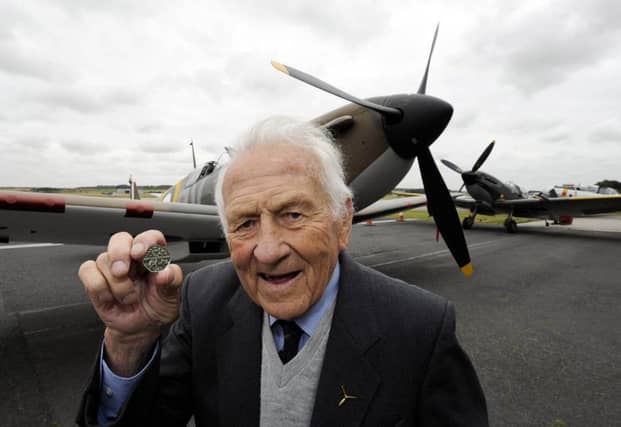 Squadron leader Tony Pickering, who fought alongside fellow RAF airmen known as The Few, inspects a new Battle of Britain 50p coin. Picture: PA
