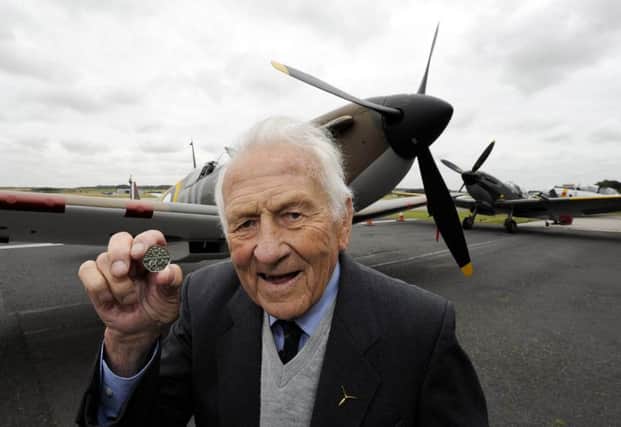 Squadron leader Tony Pickering, who fought alongside fellow RAF airmen known as The Few, inspects a new Battle of Britain 50p coin. Picture: PA