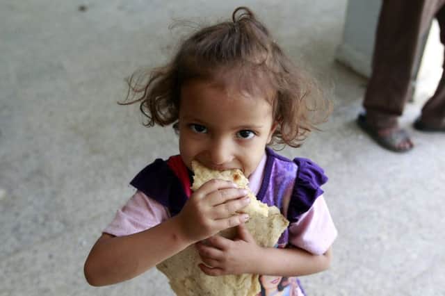 A Yemeni child gets a rare meal after her family fled fighting. All sides in the conflict must approve aid for it to be viable. Picture:AFP/Getty