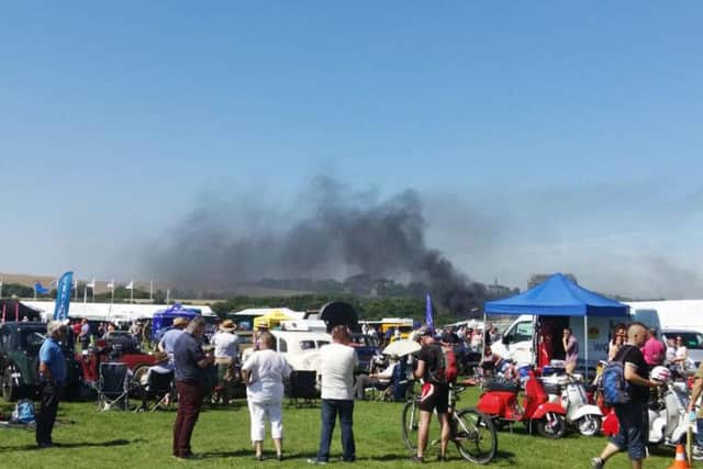 Onlookers watch as smoke rises following a crash involving a plane near Shoreham Airshow in West Sussex. Picture: PA