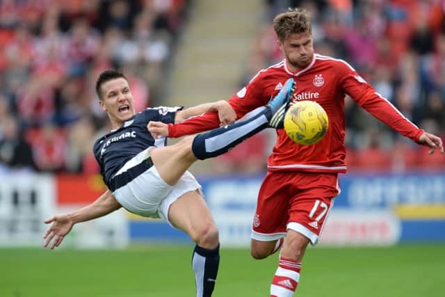 Dundees Thomas Konrad makes a desperate lunge in his bid to dispossess Aberdeens David Goodwillie. Picture: SNS