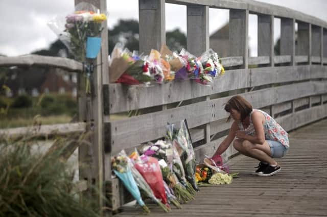 A woman lays flowers near the scene of the crash. Picture: PA
