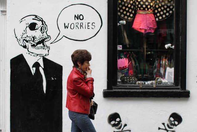 A shopper walks past graffiti in Dublin, home of the Celtic tiger, whose economy bears similarities to that of China. Picture: AFP/Getty