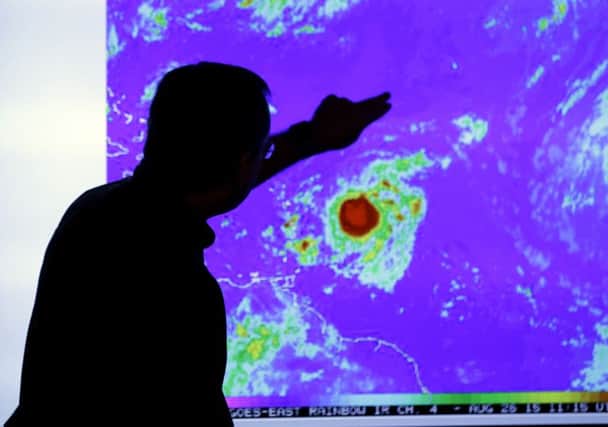 Hurricane forecaster James Franklin shows Tropical Storm Erika as it heads westwards. Picture: AP