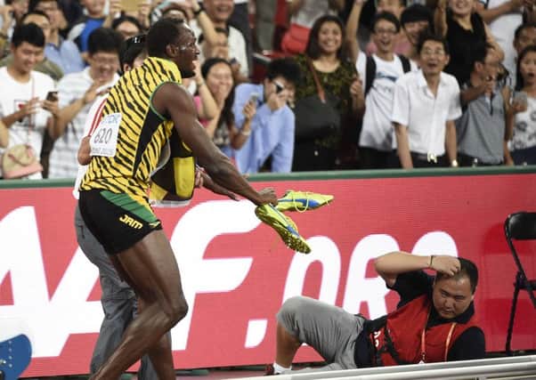 Usain Bolt reacts after a cameraman on a segway crashed into him in the final of the men's 200 metres event/ Picture: AFP/Getty Images