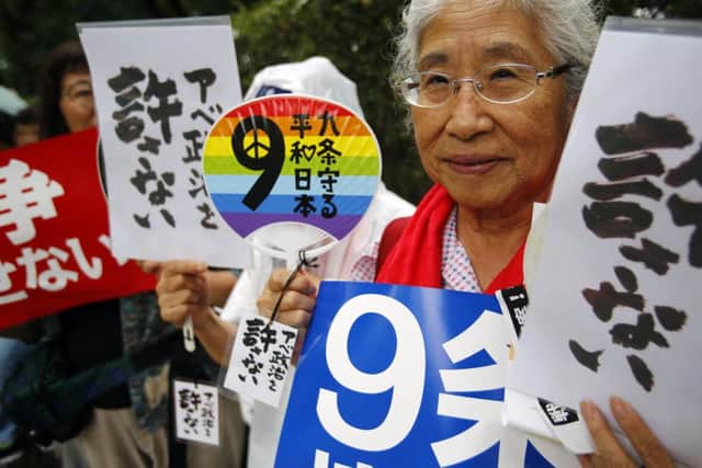 Protesters hold anti-war placards in front of the National Diet building during a rally in Tokyo yesterday. Picture: AP