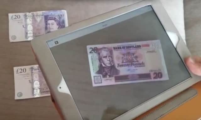 Trevor Jones puts his augmented reality app to work on some English banknotes. Picture: YouTube