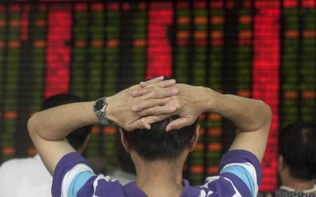 Investors show their frustration as Chinese shares plummet at a Shanghai stock brokerage yesterday. Picture: Getty