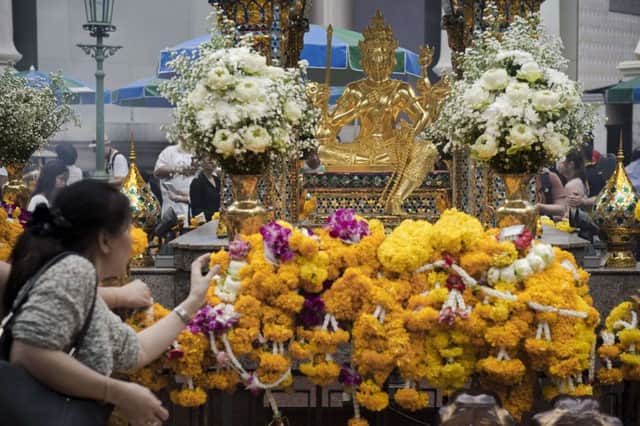 A woman lays a garland in front of the Brahma statue at the Erawan Shrine yesterday. Picture: Getty
